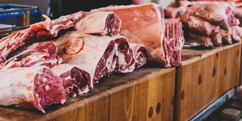 Frisch zerlegtes Fleisch auf einem Holzblock in einer Fleischerei