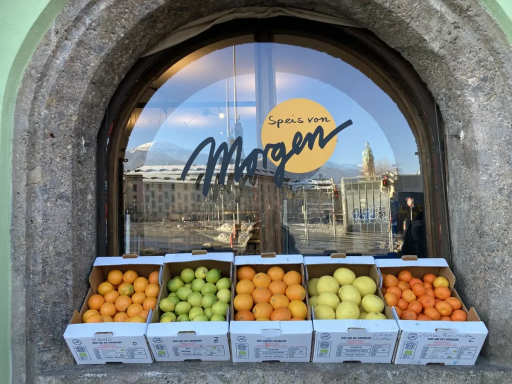Rundbogenfenster von Speis von Morgen in Innsbruck mit Logo und Obstkisten